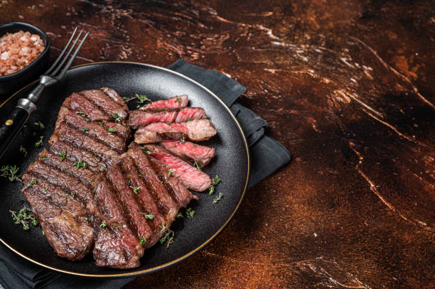 istock Barbecue denver strip beef meat steak on a plate. Dark background. Top view. Copy space 2161128663