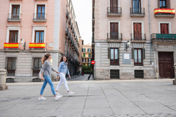 istock Two Friends Exploring Madrid Streets with Spanish Flags 2161134739