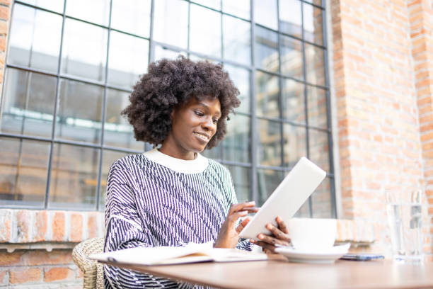 istock Woman using tablet outside at cafe with coffee 2161135659