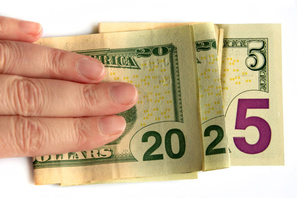 istock 2025 written with dollars bank notes in a hand isolated on white background, budget and finances new year money concept 2161135951