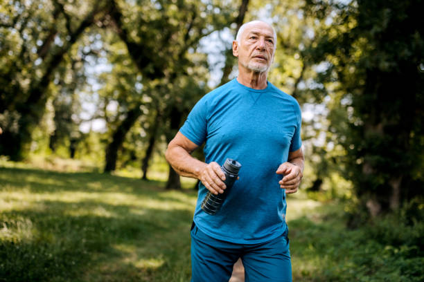 istock Athletic senior man running in forest 2161136143