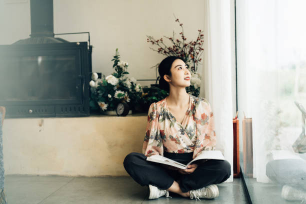 istock Young Asian woman with book 2161136161