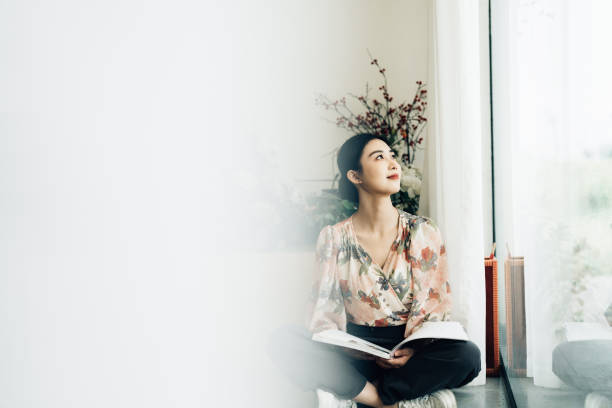 istock Young Asian woman with book 2161136162