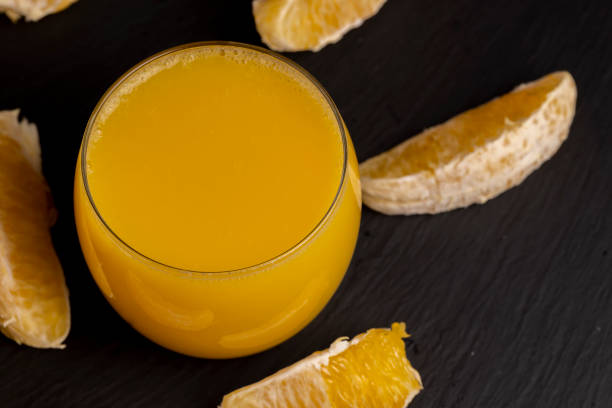 orange juice from a ripe orange in close-up, delicious peeled orange and juice