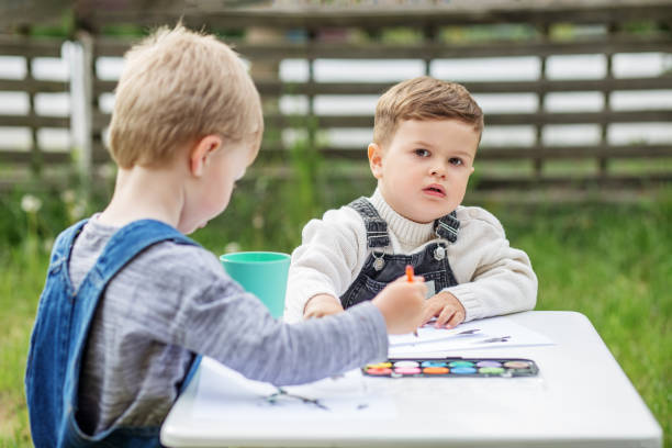 istock Two Little Boys Painting Outdoors at Table 2161139711