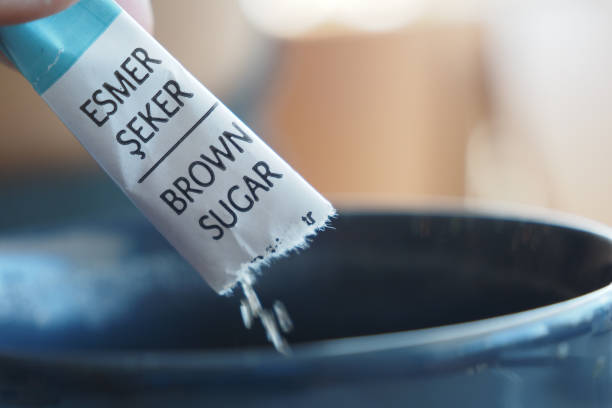 istock brown sugar in a paper packet pouring 2161140252