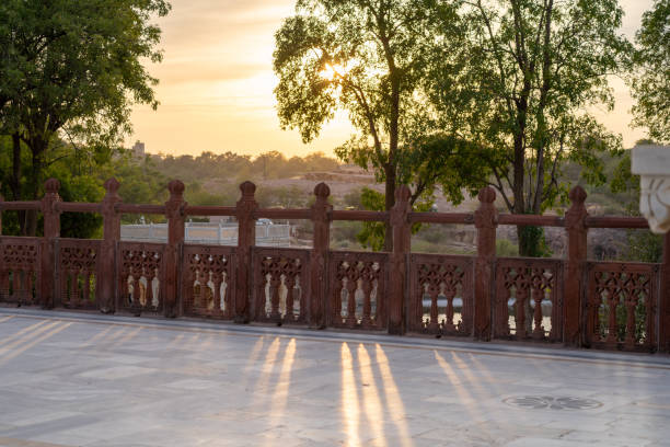 Early morning dawn dusk sunlight filtering through railing on walkway with trees showing rajput architecture in rajasthan India