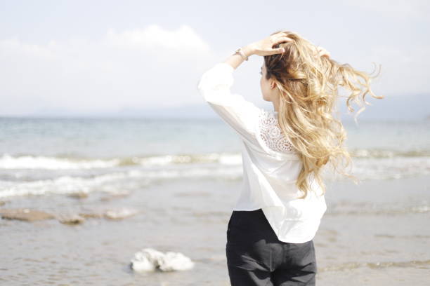 istock blonde haired woman spending time on the beach 2161145212