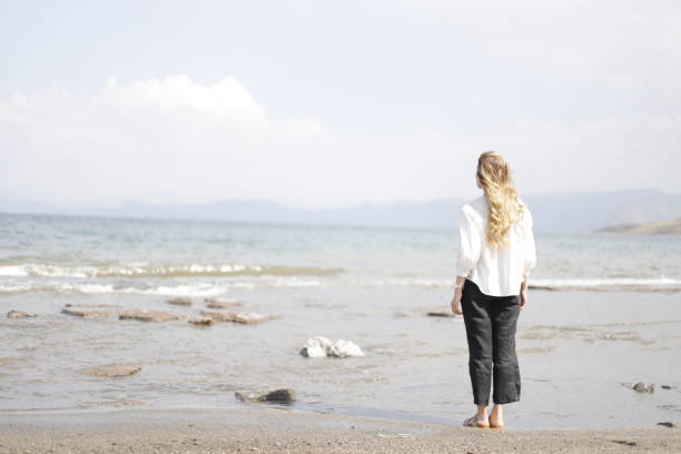 istock blonde haired woman spending time on the beach 2161145223