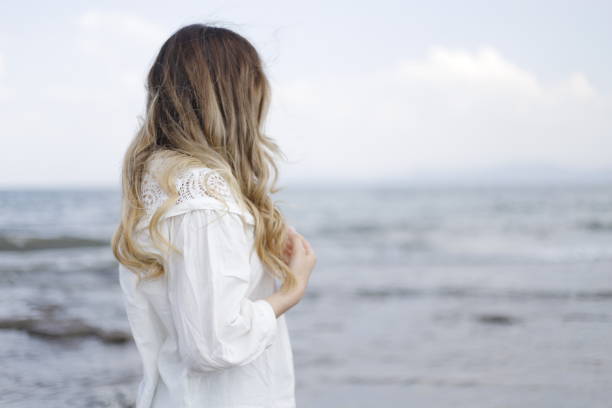 istock blonde haired woman spending time on the beach 2161145256