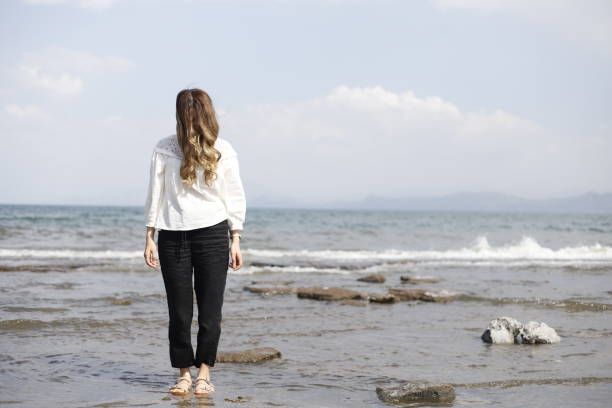 istock blonde haired woman spending time on the beach 2161145333