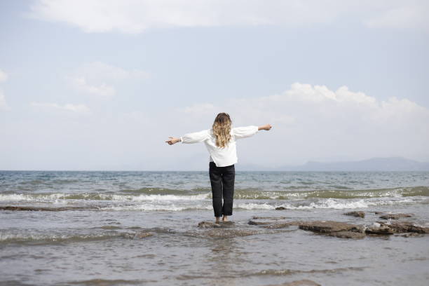 istock blonde haired woman spending time on the beach 2161145347