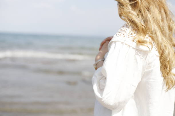 istock blonde haired woman spending time on the beach 2161145366