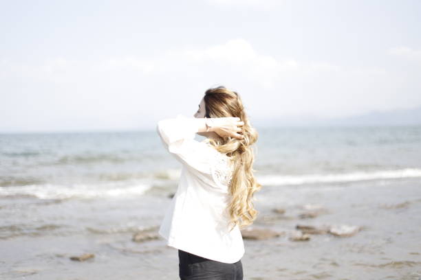 istock blonde haired woman spending time on the beach 2161145548