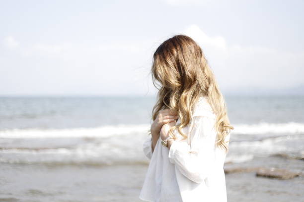 istock blonde haired woman spending time on the beach 2161145585