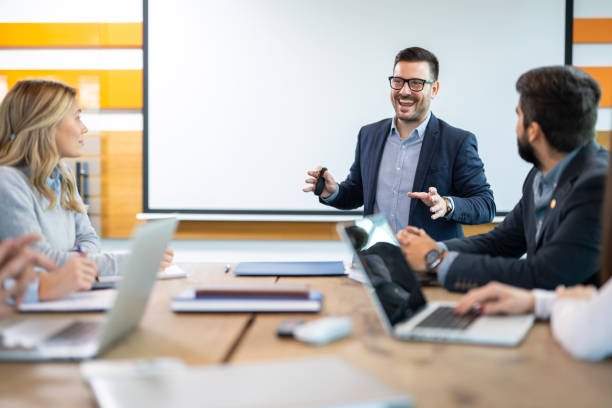 istock Businessman explaining something and smiling while talking to his colleagues at the conference. 2161148414