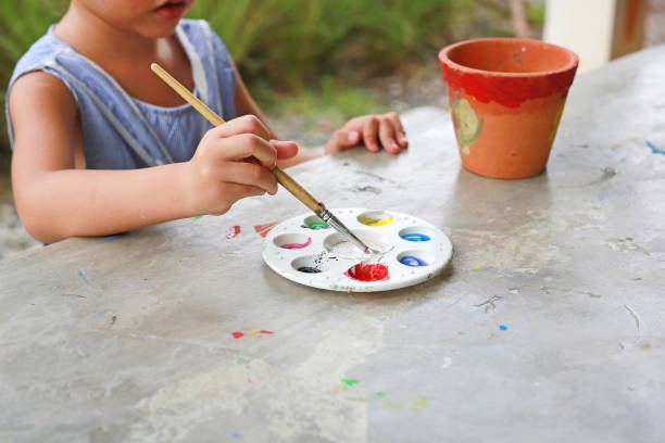 istock Close-up Asian kid girl paint on earthenware dish. 2161151738