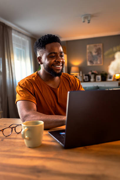 istock Young African American man sitting at home using laptop for video call. 2161151956
