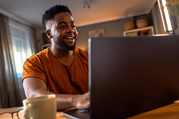 istock Young African American man sitting at home using laptop for video call. 2161152040