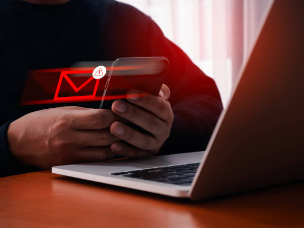 istock SMS spam and fake text message phishing from scammer concept. SMS hacked warning alert, forward mail or E-mail with mobile smart phone by anonymous hacker, scam malware spreading virus, cybercrime. 2161153000