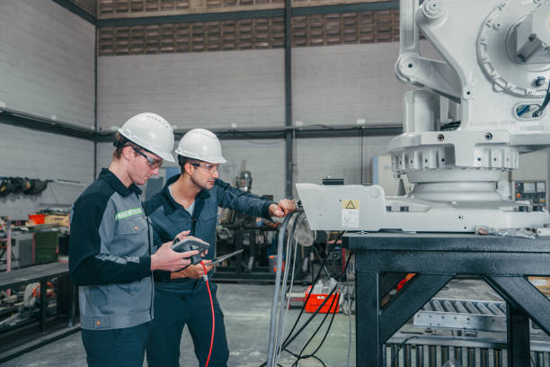 istock Two industrial engineers are working and inspecting Robotic Arm. 2161156997