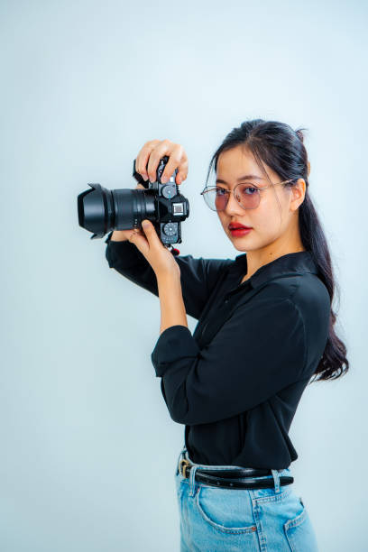 istock Female photographer holding a camera in the studio 2161158234