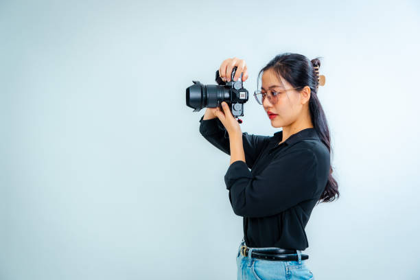 istock Female photographer holding a camera in the studio 2161158237