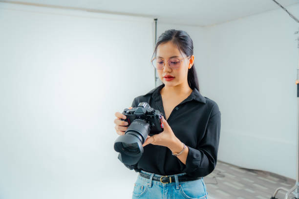 istock Female photographer holding a camera in the studio 2161158296
