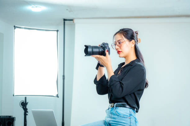istock Female photographer holding a camera in the studio 2161158370