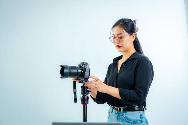istock Female photographer holding a camera in the studio 2161158371