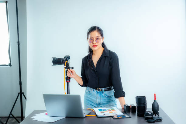 istock Female photographer holding a camera in the studio 2161158390