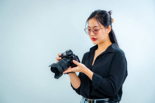 istock Female photographer holding a camera in the studio 2161158415