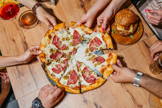 istock Six Young People Taking A Slice Of Pizza In A Pub 2161159067
