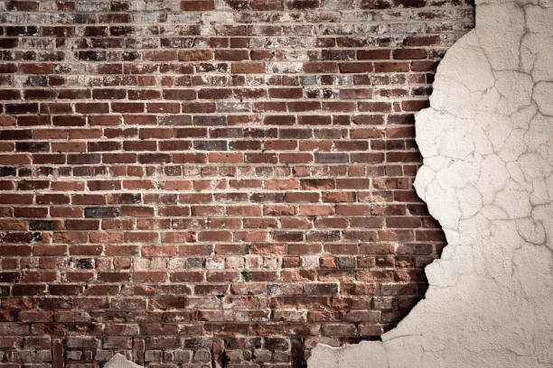 istock Vintage brick wall with cracked and crumbling stucco 2161159191