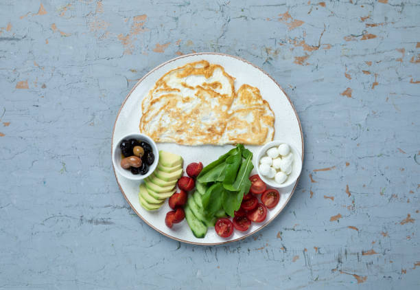 istock Simple omelet on a beautiful background, topped with olives, tomatoes and cheese 2161171393