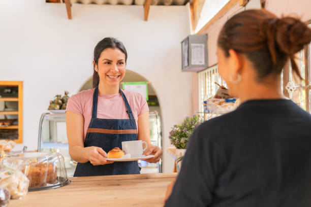 istock Happy waitress serving a client at a coffee shop 2161171607