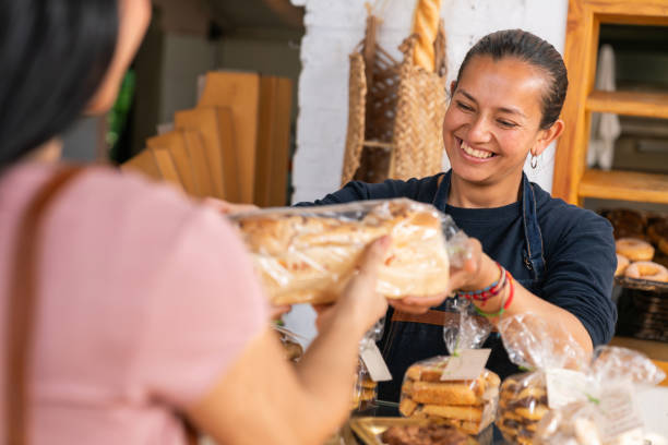 istock Retail clerk selling bread to a customer at the bakery 2161172326