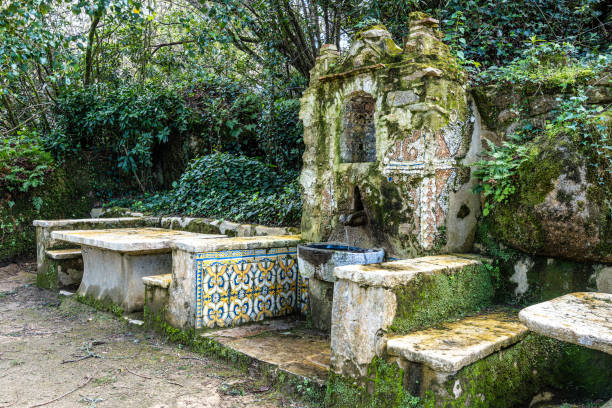 Sintra, Portugal - December 18, 2018: Located in Quinta da Regaleira, it is an ornate fountain symbolizing prosperity and wealth. Designed in harmony with the estate's symbolic architecture, it reflects the themes of abundance and nature's bounty. This hidden gem enriches the mystical atmosphere of Quinta da Regaleira, captivating visitors with its intricate design.