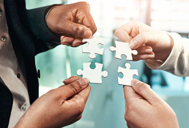 istock Puzzle, team building and hands of business people for strategy, partnership and solution. Work, corporate and a group of employees with a jigsaw for an idea, mission or company problem solving 2161177166