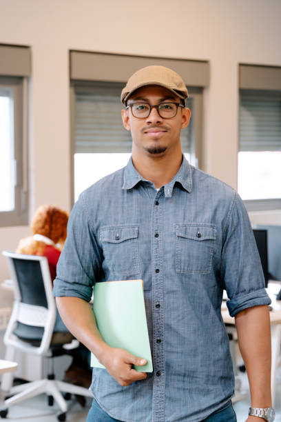 istock A confident professional man in casual attire holding a document in a modern office environment 2161179607