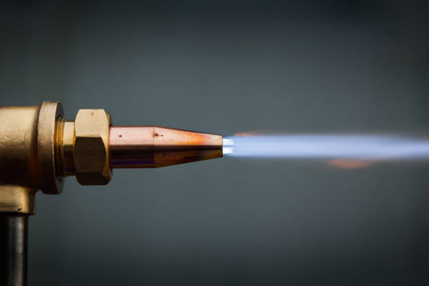 Gas cutter with copper nozzle with a stream of fire.
