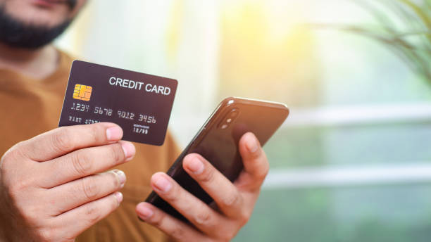 istock Man Using Smartphone Shopping Online Holding Credit Card Making Payment At Home.  Mobile payment with wallet app technology. Internet Banking Application And E-Commerce, Digital money transfer 2161185446