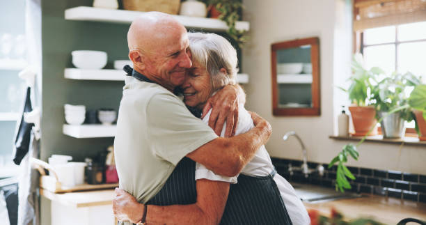 istock Kitchen, hug and senior couple in home for love, bonding relationship and commitment together. Marriage, happy and elderly man and woman cooking together for wellness, meal prep and health in house 2161185502