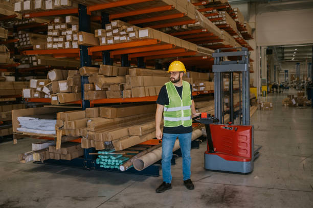 istock Warehouse worker operating a forklift near shelving units 2161188112