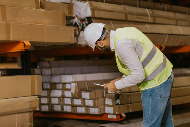 istock Warehouse worker checking inventory of cardboard boxes 2161188462