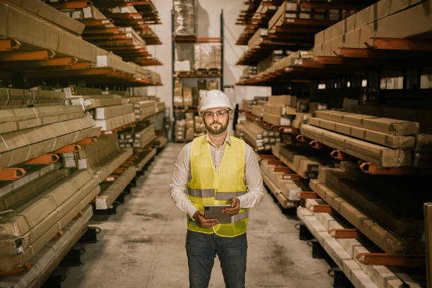 istock Warehouse worker holding tablet in front of shelving units 2161188691