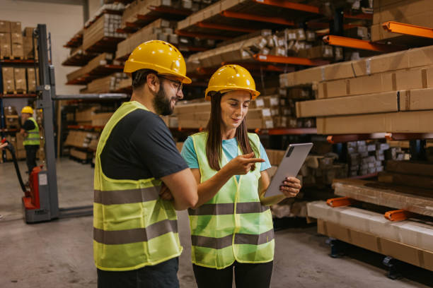 istock Two workers reviewing inventory on a tablet in a busy warehouse 2161189213