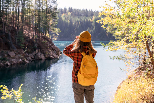 istock Woman observing birds through binoculars by a lake 2161189862