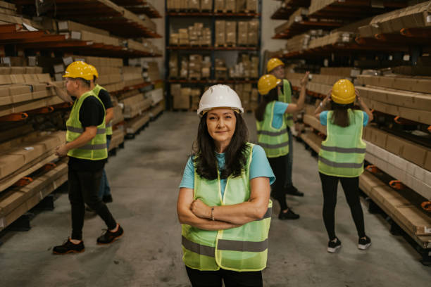 istock Warehouse workers wearing safety vests and hard hats 2161189878