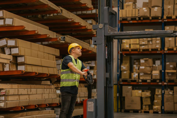 istock Warehouse worker operating forklift near cardboard boxes 2161190132